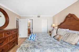 a bedroom with a large bed with a wooden headboard at Caprice Resort 305 in St. Pete Beach +43 photos