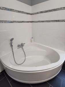 a white tub in a bathroom with a shower at Appartement 3 chambres au cœur du Jura, idéal famille in Salins-les-Bains +21 photos