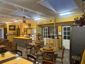a restaurant with tables and chairs and a kitchen at Hostal Maipu Street in Punta Arenas