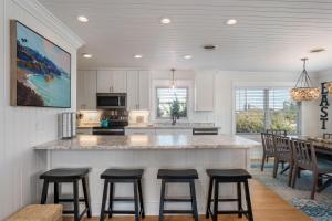 a kitchen with a large island with bar stools at SH125 Here & Now in Southern Shores