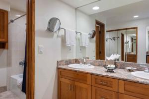 Un baño con dos lavabos y un espejo grande. en The Charter at Beaver Creek E045, en Beaver Creek