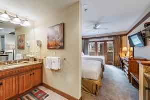 Un dormitorio con una cama y un baño con lavabo. en The Charter at Beaver Creek E115, en Beaver Creek