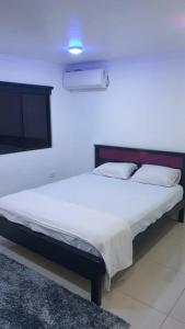 a bedroom with a large bed with a white bedspread at Kianna Apartments in Mba