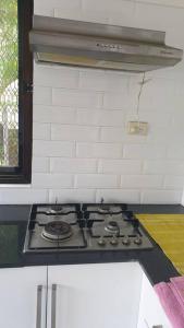 a stove top oven in a kitchen with white tiles at Kianna Apartments in Mba +2 photos