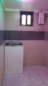 a small bathroom with a sink and a window at Kianna Apartments in Mba