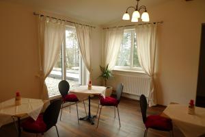 a dining room with two tables and chairs and windows at Pension Marillenhof in Melk