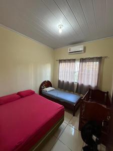 a bedroom with a red bed and a couch at CARAVELAS in Três Marias