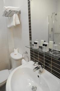 
a bathroom with a sink, toilet and mirror at The Coach House Hotel in Oranmore
