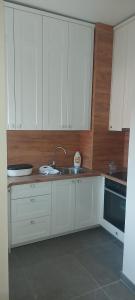 a kitchen with white cabinets and a sink at Apartman Oaza Tuzla in Tuzla