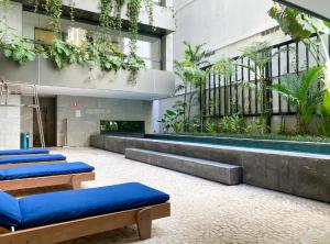 a building with a row of blue pillows in front of a pool at Copacabana Amazing in Rio de Janeiro