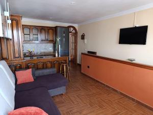 a living room with a couch and a flat screen tv at Casa Los Dises in Caleta de Caballo