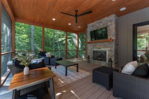 a living room with a fireplace and a tv at The Creeks of Serendipity in Black Mountain