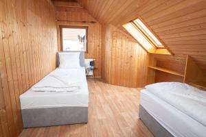 a bedroom with two beds in a wooden cabin at RANGE - Landhaus mit Panoramablick - 2 Apartments - Parkplatz - Küche - WLAN - Monteure 1-11 Personen in Winterbach