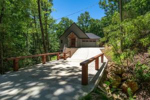 a wooden walkway leading to a cabin in the woods at The Creeks of Serendipity in Black Mountain