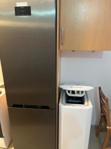 a stainless steel refrigerator in a kitchen with a dishwasher at Glifa Beach House Maisonette in Glida