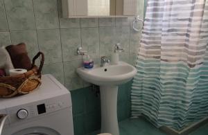 a bathroom with a sink and a washing machine at Ampolias rooms Messolonghi in Missolonghi +14 photos