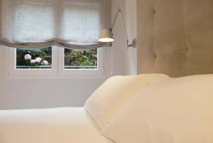 a bedroom with a white bed and a window at Tu lugar en la playa in Luanco +23 photos