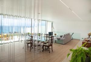 a dining room with a table and chairs in a living room at Casa Neptuno-Lagoa São Miguel in Lagoa