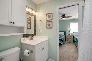 a bathroom with a sink and a mirror and a bedroom at ONHC11D Sunwatch in Nags Head +58 photos