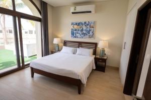 Un dormitorio con una cama y una ventana grande. en Luxury Salalah Villa, en Salalah 12 fotos más