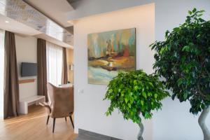 a living room with a chair and a painting on the wall at Gaura Apartments in Trapani