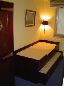 a bed in a room with a light on the wall at Knokke-Zoute Topligging in Knokke-Heist