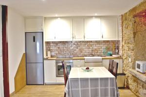 una cocina con una mesa y un refrigerador en Casa Grille, en Cee