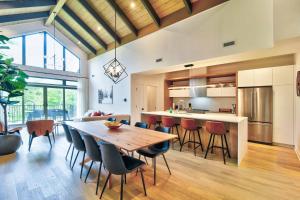 a kitchen and dining room with a wooden table and chairs at Verbier C - Mont-Tremblant Pool Spa and Gym in Mont-Tremblant