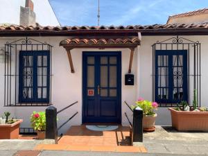 a house with a blue door and two windows at La casita de Kalani in Comillas