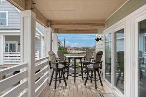 une terrasse couverte avec des chaises et une table. dans l'établissement NH387D Cape Lookout Cottage, à Nags Head