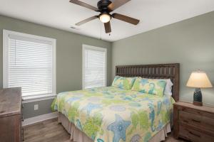 une chambre avec un lit et un ventilateur de plafond dans l'établissement NH387D Cape Lookout Cottage, à Nags Head 35 autres photos