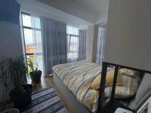 a bedroom with a bed and a large window at BRT Apartment in Floreşti