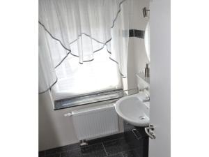 a bathroom with a sink and a window at Holiday home Robbenplatte House 5 in Burhave +18 photos