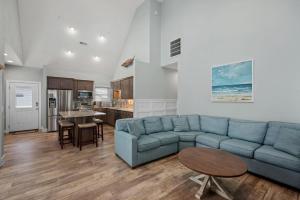 un salon avec un canapé bleu et une table dans l'établissement NH387C Oak Island Cottage, à Nags Head