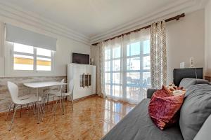 a living room with a couch and a table at Tenerifeopenhome Costa Adeje comfort apartment 3 pools in Adeje