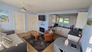 una sala de estar con un sofá y una mesa en 20 sea valley, en Bideford