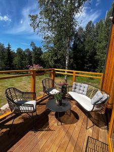 a deck with two chairs and a couch and a table at ARKA Puhkemajad in Päidre +24 photos