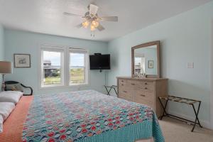 a bedroom with a bed and a dresser and a mirror at NH380 Pelican View in Nags Head +49 photos
