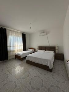 a hotel room with two beds and a window at The Cuni Castle in Shkodër