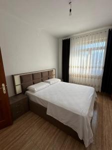 a bedroom with a large bed and a window at The Cuni Castle in Shkodër