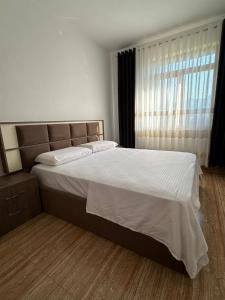 a bedroom with a large bed and a window at The Cuni Castle in Shkodër +1 photo
