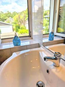ein weißes Waschbecken im Bad mit Fenster in der Unterkunft Ferienwohnung Am Fenn in Potsdam