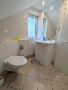 ein Badezimmer mit Toilette und Waschbecken und einem Fenster in der Unterkunft Ferienwohnung Am Fenn in Potsdam