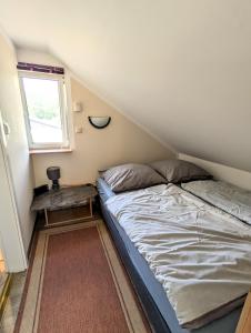 ein kleines Schlafzimmer mit einem Bett und einem Tisch in der Unterkunft Ferienwohnung Am Fenn in Potsdam