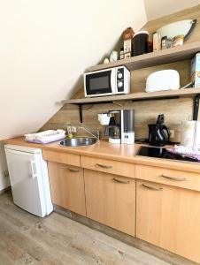 eine Küche mit Spüle und Mikrowelle in der Unterkunft Ferienwohnung Am Fenn in Potsdam + 10 Fotos