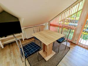 einen Tisch und 2 Stühle in einem Zimmer mit einem TV in der Unterkunft Ferienwohnung Am Fenn in Potsdam