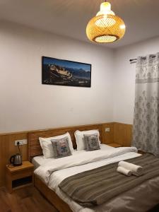 a bedroom with a bed and a chandelier at The Shangbar in Jispa