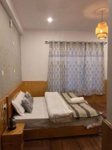 a bedroom with a bed with a curtain and a window at The Shangbar in Jispa +18 photos