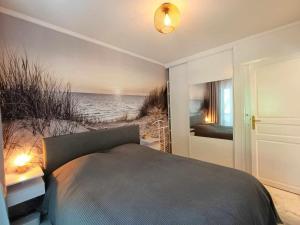 a bedroom with a bed and a view of the beach at La Résidence Fleuries - Plage in Cannes
