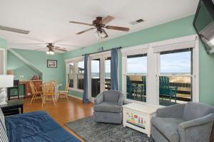 a living room with a couch and chairs and windows at NH333 Capt Brad's in Nags Head